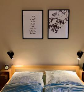 1 dormitorio con 2 cuadros en la pared y 2 camas en Fewo 5 Jahreszeiten, en Bell