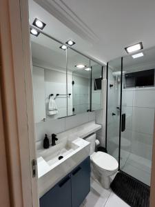 ein Badezimmer mit Waschbecken, Toilette und Spiegel in der Unterkunft Apê Completo - Aeroporto 4 min in Aracaju