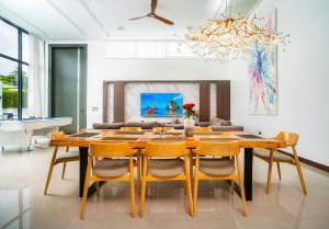 ein Esszimmer mit Tisch und Stühlen in der Unterkunft Villa Astra - 4BR Entertainment Pool Villa, Rawai in Ban Kata