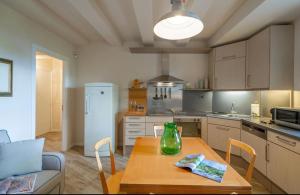 eine Küche mit einem Tisch mit einer Vase darauf in der Unterkunft Ferienwohnung Le Volte in der Residenza dei Piaceri Perduti in Lastra a Signa