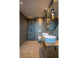 a bathroom with a tub and two toilets and a sink at Modern villa in De Cocksdorp near the beach in De Cocksdorp