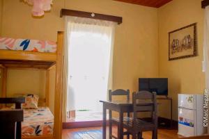 a bedroom with a bunk bed and a desk and a window at Three Palms Fianar in Fianarantsoa