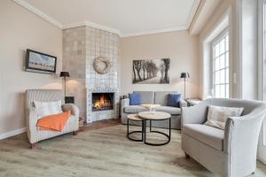 a living room with two chairs and a fireplace at Wattlaeufer in Keitum