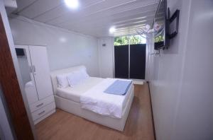 una piccola camera da letto con un letto e una finestra di Capital O 91243 Bee Good Chalet a Yan