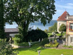 a house with a tree and a lake in the background at Am Gallerturm mit Seeblick in Überlingen