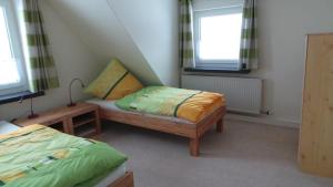 een kleine kamer met 2 bedden en 2 ramen bij Fewo Am Skihang Og in Eibenstock