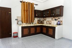 a kitchen with wooden cabinets and a counter top at behind ocean villa in Weligama