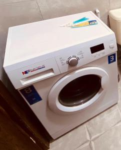 a white washing machine sitting in a bathroom at New Roman's kingdom in Madaba