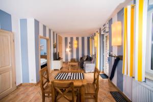 a dining room with blue and yellow striped walls at Villa Mare Apartamenty in Grzybowo