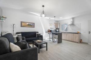 Una sala de estar con un sofá y una cocina. en 1 Apartamentos Omanai Tenerife Sur, en Las Galletas