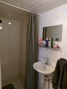 a bathroom with a sink and a shower with a shower curtain at Beach Quarter in Ons Belang