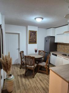 Una cocina con una mesa y sillas en una habitación. en Apartman Barok, en Banja Luka