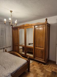 1 dormitorio con armario de madera y cama en Apartman Barok, en Banja Luka