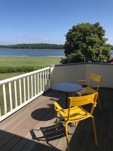 a table and chairs sitting on a deck with a table and chairs at Wohnung Im Zweiten Obergeschoss Des Gutshauses in Neuenkirchen