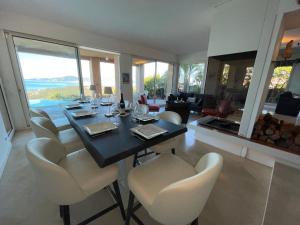 a dining room with a table and chairs with a view at Villa de standing 12 couchages - vue sur mer - piscine à débordement chauffée in Albitreccia