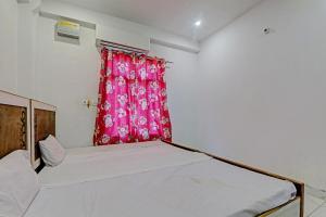 a bedroom with a bed and a red curtain at Hotel O ONCE MORE RESTAURANT AND CAFE in Prayagraj