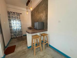 Una cocina con una barra con dos taburetes. en Villa Komalee, en Unawatuna 31 fotos más