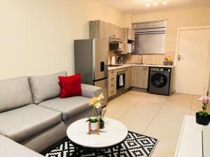 ein Wohnzimmer mit Sofa und Tisch in der Unterkunft Cozy getaway in Midrand