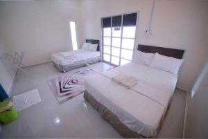 una camera da letto con due letti e una finestra di Capital O 91243 Bee Good Chalet a Yan Altre 35 foto