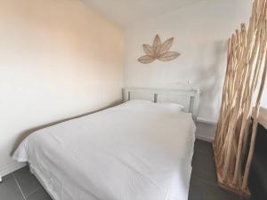 a bedroom with a white bed with a butterfly on the wall at Sunset View , Studio , Parking & Wifi in Villers-sur-Mer