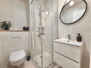 a bathroom with a shower and a toilet and a sink at Sunset View , Studio , Parking & Wifi in Villers-sur-Mer