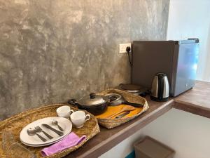 una mesa con platos y utensilios junto a una cafetera en Villa Komalee, en Unawatuna