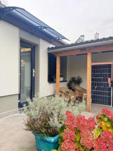a patio with flowers in front of a house at Süßes Gästehäuschen in 1A Lage in Bochum +6 photos