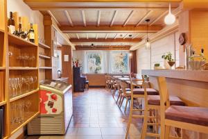a restaurant with a bar with a table and chairs at Kreativ Hotel Landhaus Schweigl in Ultimo