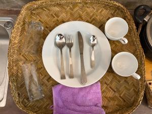 una mesa con un plato blanco con cubiertos encima en Villa Komalee, en Unawatuna