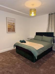 ein Schlafzimmer mit einem großen Bett mit Kronleuchter in der Unterkunft City Centre 2 Bed with Ensuite Rooms Wakefield in Wakefield