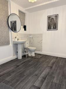 ein Badezimmer mit Waschbecken, Toilette und Spiegel in der Unterkunft City Centre 2 Bed with Ensuite Rooms Wakefield in Wakefield