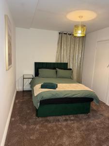 ein Schlafzimmer mit einem großen Bett mit grünem Kopfteil in der Unterkunft City Centre 2 Bed with Ensuite Rooms Wakefield in Wakefield