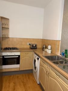 eine Küche mit Spüle und Waschmaschine in der Unterkunft City Centre 2 Bed with Ensuite Rooms Wakefield in Wakefield + 35 Fotos