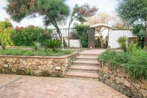 a garden with a stone retaining wall and stairs at Villa Giglio Marino in Paestum