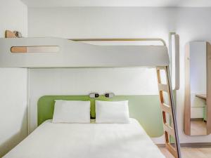 a bunk bed with two white pillows in a room at ibis Budget Caen Memorial in Caen +17 photos