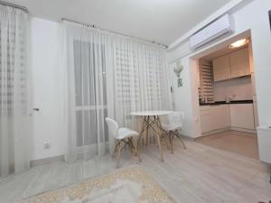 a room with a table and chairs and a kitchen at Apartament Klonowa in Kraśnik