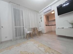 a living room with a television and a table and chairs at Apartament Klonowa in Kraśnik +9 photos