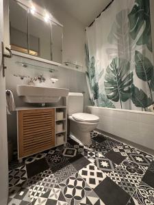 a bathroom with a sink and a toilet and a shower curtain at Alpine Hideaway - Cozy Mountainview Studio, Free Parking, Ski, Engelberg, Luzern in Engelberg