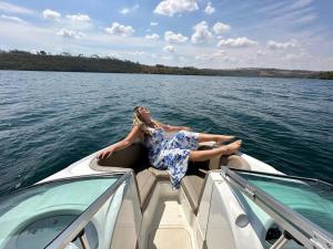 una mujer sentada en la parte trasera de un barco en el agua en Flamboyant Boat, en Ubatuba