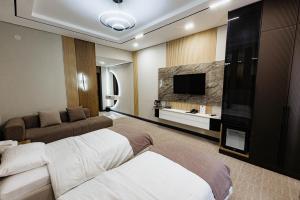 a hotel room with two beds and a flat screen tv at Residence Hotel Spa in Taraz