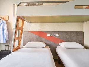 Postel nebo postele na pokoji v ubytování ibis budget Paris Porte d'Aubervilliers + 105 fotografií