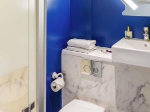 a bathroom with a white sink and a toilet at ibis budget Senlis in Senlis