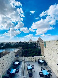 a patio with tables and chairs on top of a building at Saqqara Nights Hotel in Cairo