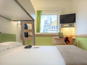 Un dormitorio con una cama y un televisor y una ventana. en ibis budget Sao Paulo Paraiso, en São Paulo 78 fotos más