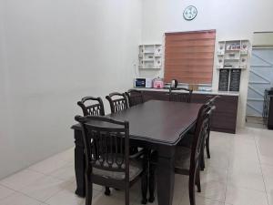 a dining room with a table and chairs at Lakeville Inn in Seri Iskandar