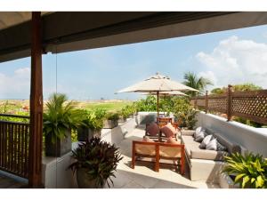 a patio with an umbrella and a couch and chairs at Pool, Roof Terrace, 3 Bedroom Villa, Galle Fort in Galle