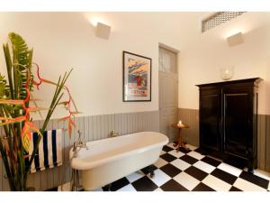 a bath tub in a bathroom with a checkered floor at Pool, Roof Terrace, 3 Bedroom Villa, Galle Fort in Galle +52 photos