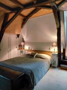 a bedroom with a large bed in a room with beams at LES TALOCHES in Tourtoirac