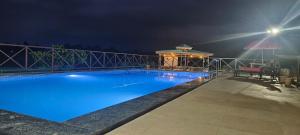 a swimming pool at night with a gazebo at The Malshej Mist in Ghātghar