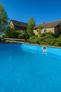 a large pool of blue water in front of a house at Saisonnée in Centrès